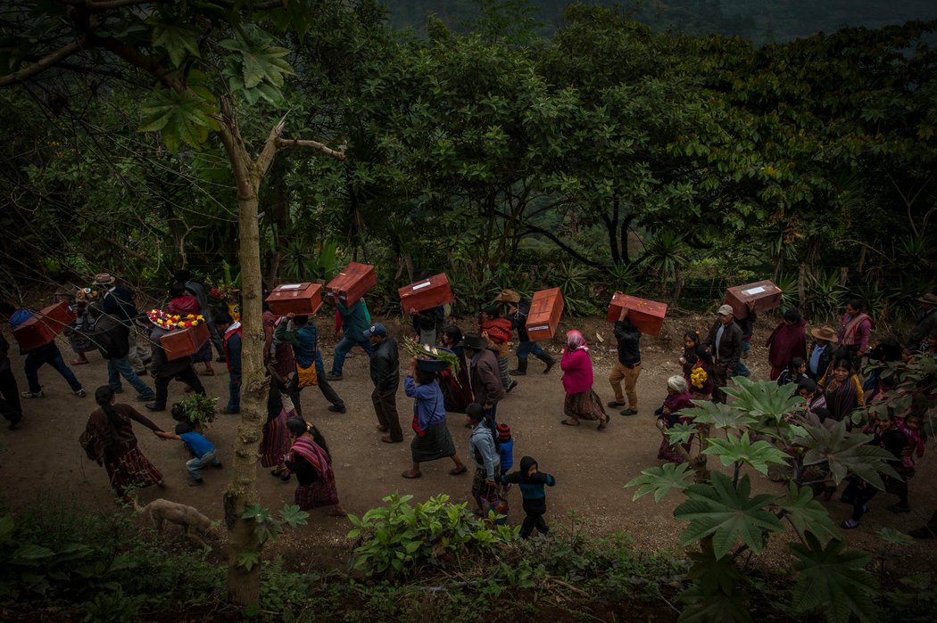 Un grupo de familiares transporta los féretros con los restos de 172 personas que murieron durante la guerra civil guatemalteca y fueron exhumados en 2014. Los restos fueron enterrados en diciembre en un cementerio en Santa Avelina, Guatemala. Credit Daniele Volpe para The New York Times